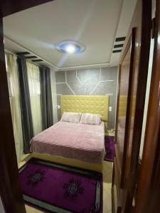 a small bedroom with a bed with purple carpet at la paix in Ifrane