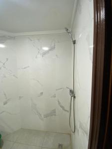 a bathroom with a shower with white marble walls at la paix in Ifrane
