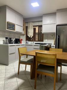 cocina con mesa de madera y sillas en Casa em Bombinhas Próximo a Praia, en Bombinhas