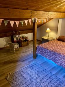 a bedroom with a bed and a table with a lamp at Chez papa et maman in Eaux-Bonnes