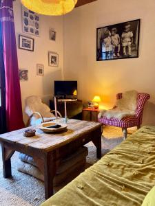 a living room with a wooden table and a couch at Chez papa et maman in Eaux-Bonnes