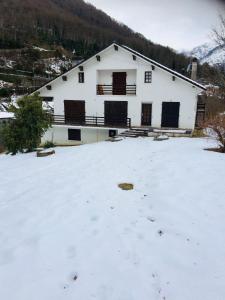 a white house with snow in front of it at Chez papa et maman in Eaux-Bonnes