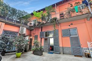een oranje gebouw met planten ervoor bij DF MiniLOFT, Milano-SanSiro in Milaan