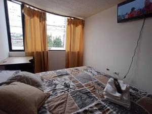 a bedroom with a bed with a remote control on it at Casa Amoblada y Equipada, Completamente Privada in Ibarra