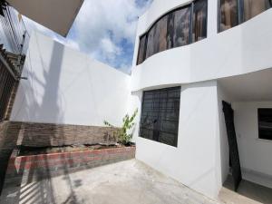 a white building with a brick wall and a window at Casa Amoblada y Equipada, Completamente Privada in Ibarra