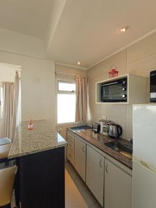 皮納馬爾的住宿－5 Soles II，厨房配有柜台、水槽和冰箱。