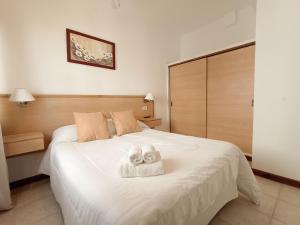 皮納馬爾的住宿－5 Soles II，卧室配有带毛巾的大型白色床