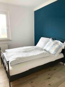 a bed in a room with a blue wall at Im Herzen von Haltern am See in Haltern