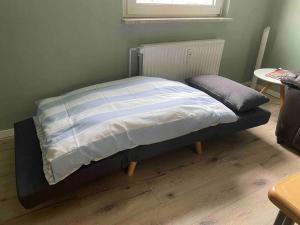 a bed with a blue and white comforter in a bedroom at Im Herzen von Haltern am See in Haltern