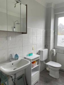 a white bathroom with a sink and a toilet at Im Herzen von Haltern am See in Haltern