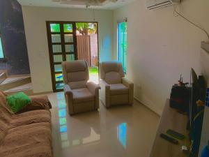 two chairs and a couch in a living room at CASA EM PORTO DE GALINHAS in Porto De Galinhas