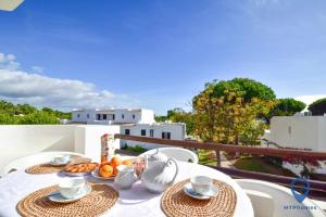 a table with plates of food on a balcony at Balaia Golf by MTPhomes in Albufeira
