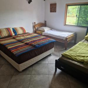 a room with three beds and a window at Casa-Miri in Piribebuy