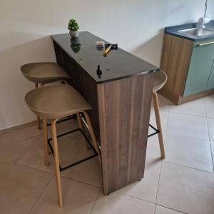 a kitchen island with two stools and a sink at Casa-Miri in Piribebuy