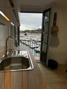 eine Küche mit einem Waschbecken und Blick auf den Yachthafen in der Unterkunft ISTUA - Etxie La Casa in Bermeo