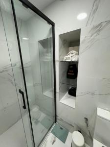 y baño con ducha de cristal y aseo. en ISTUA - Etxie La Casa, en Bermeo