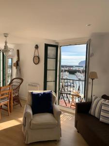 a living room with a couch and a view of a harbor at ISTUA - Etxie La Casa in Bermeo