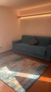 a blue couch in a living room with a rug at LUW casa a Madonna di Campiglio in Madonna di Campiglio