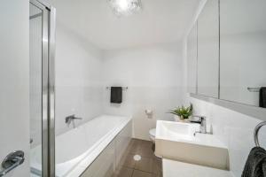 biała łazienka z wanną i umywalką w obiekcie Celeste on Charles 2BR Parking WiFi w mieście Plympton