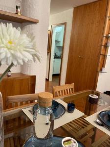 a dining room table with a glass bottle with a flower at LUW casa a Madonna di Campiglio in Madonna di Campiglio