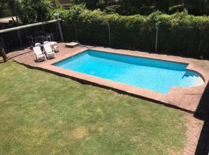 a swimming pool with two chairs and a table at Mi Bella Vista - Quinta Con Pileta in Bella Vista