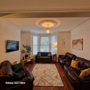 uma sala de estar com sofás de couro e uma televisão em 4 Bed Park View House-Free Parking - Sleep 8 em Plymouth