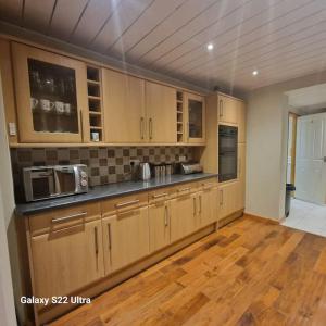 eine große Küche mit Holzschränken und Holzböden in der Unterkunft 4 Bed Park View House-Free Parking - Sleep 8 in Plymouth