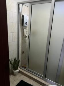 um chuveiro com uma porta de vidro na casa de banho em Beniez apartment em Kampala