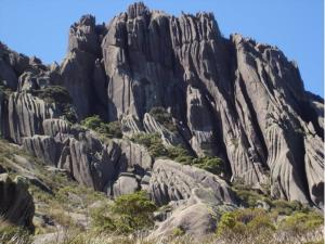 a rocky mountain with trees in front of it at Casa da Olga Itatiaia in Itatiaia