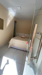 1 dormitorio pequeño con 1 cama y TV en Pousada Floripes, en Morro de São Paulo