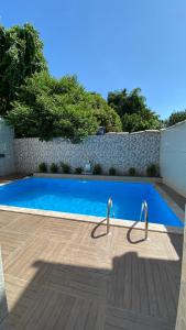 a blue swimming pool with two metal poles in it at Pousada Floripes in Morro de São Paulo