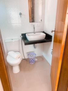 a bathroom with a white toilet and a sink at CASA EM PORTO DE GALINHAS in Porto De Galinhas
