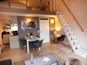 a living room and kitchen with a staircase in a tiny house at Schwarzwald Auszeit mit Sauna, Pool & Dachterrasse in Sasbachwalden