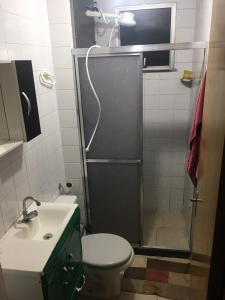 a bathroom with a shower with a toilet and a sink at Apartamento funcional in Varginha