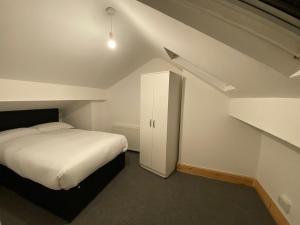 um pequeno quarto com uma cama e uma escada em Spacious 4BR Close to Digbeth em Birmingham