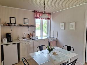 a kitchen with a table and a table and chairs at Hotell Vita Hästen Hästveda in Hästveda