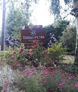 una señal en medio de un jardín con flores en Tierras del sur I en Villa La Angostura