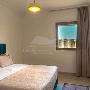 1 dormitorio con cama y ventana con vistas en Studio vue golf Taghazout Bay Tamourit en Agadir