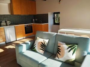 a living room with a couch and a kitchen at Casas das Japoneiras in Paredes de Coura
