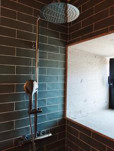 um chuveiro na casa de banho com uma parede de tijolos em Casas das Japoneiras em Paredes de Coura