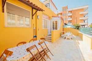 a yellow house with a table and chairs on a patio at Le Rose di Lena in Copertino