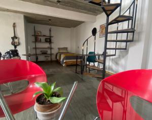 een woonkamer met rode stoelen en een wenteltrap bij Casa Leona Oaxaca in Oaxaca City