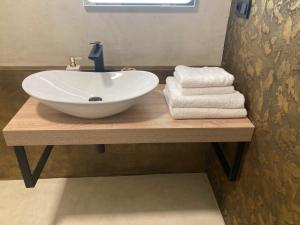 - un lavabo blanc sur un comptoir en bois avec des serviettes dans l'établissement Harrachov 702, à Harrachov