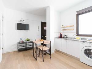 a kitchen with a table and a washing machine at Mahostly Apartamento Comillas SE in Arrecife