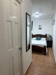1 dormitorio con cama y puerta con espejo en Hostal Compostela Inn en David