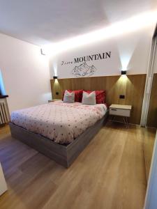 a bedroom with a bed and a sign that reads japan mountain at Appartamento con giardino in Carisolo
