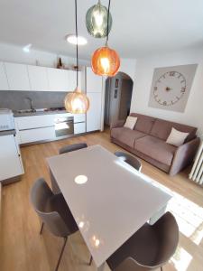 una mesa blanca y sillas en la sala de estar. en Appartamento con giardino en Carisolo