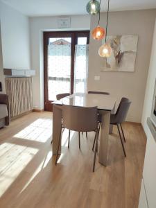 comedor con mesa y sillas en Appartamento con giardino en Carisolo
