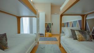 1 Schlafzimmer mit 2 Betten und einem Fenster in der Unterkunft Pedra de Sal - Hostel & Suites in Rio Maior