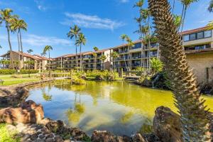 an exterior view of a resort with a pond and palm trees at Papakea E206- Updated Papakea oceanview condo, all the amenities in Kahana